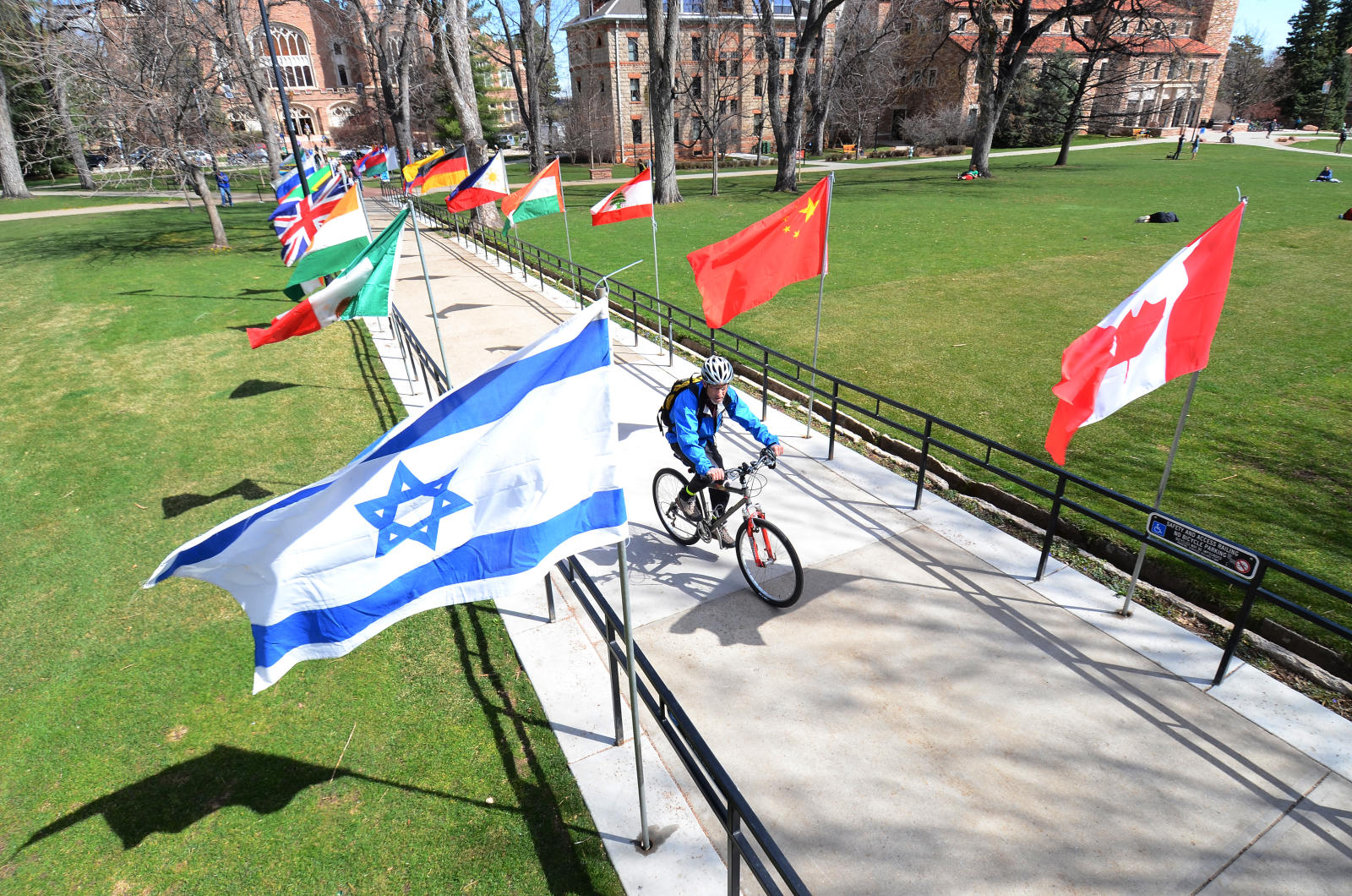 The Bold International flags line a sidewalk in Norlin Quad during the annual Conference on World Affairs at the University of Colorado Boulder