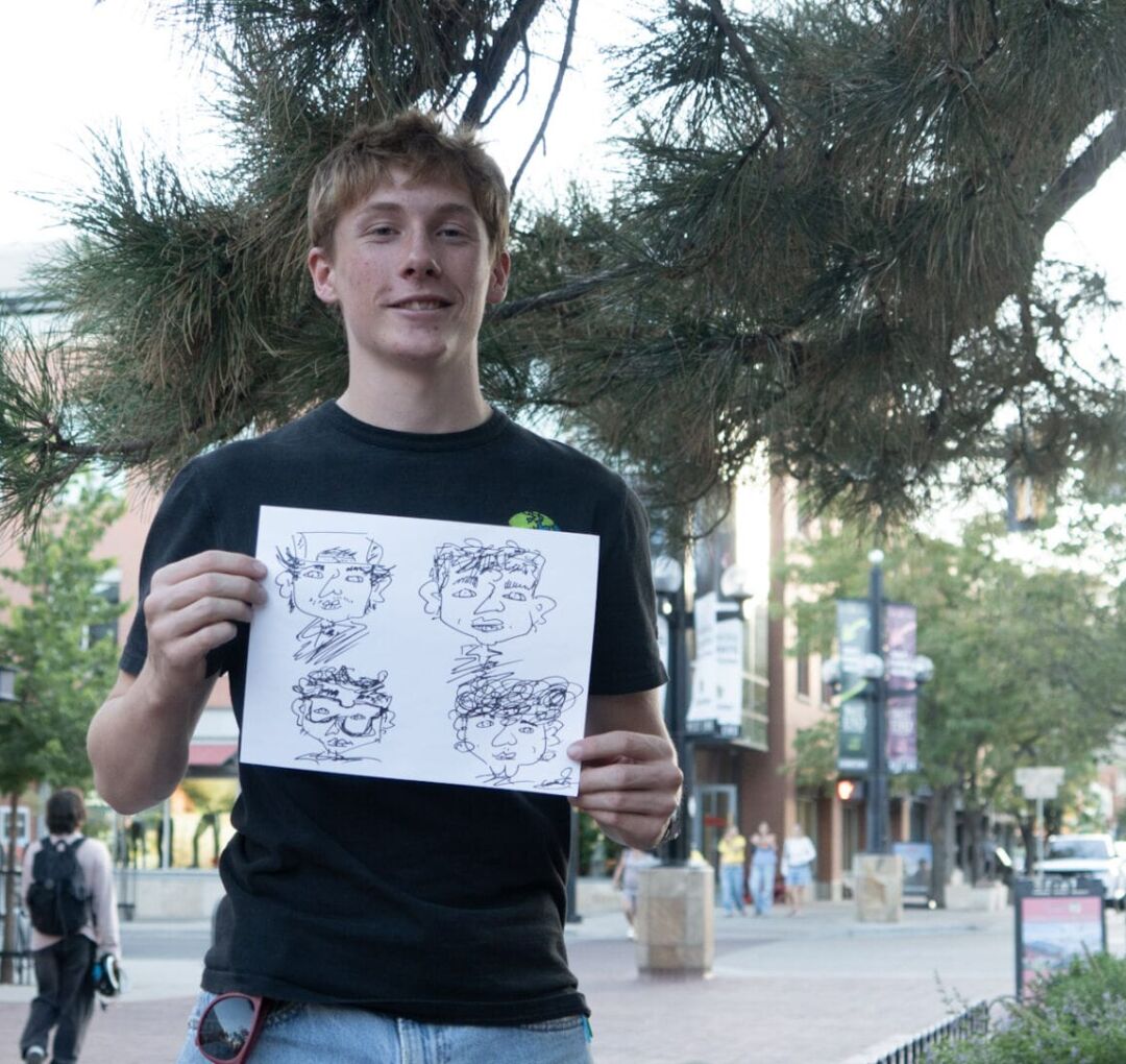 ASP00399 (1) Emerson Beckham, a 17-year-old caricature artist, holds up a drawing he did in 90 seconds that made him $20, on Pearl Street in Boulder, Colorado, on Sept. 10, 2026.
