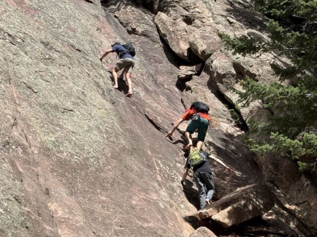 Three climbers scramble on the second Flatiron in Boulder.