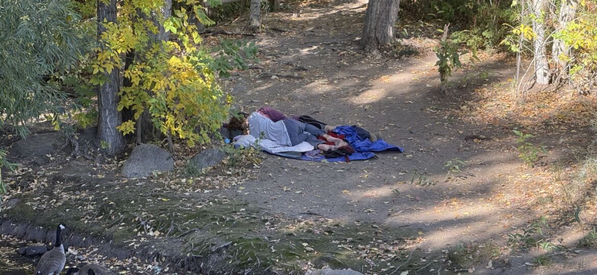 Two individuals experiencing homelessness sleep
