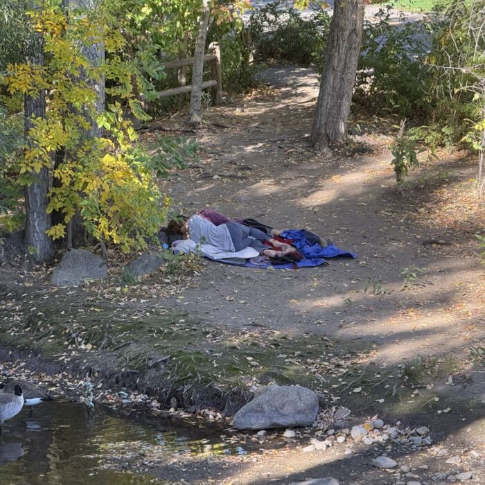 Two individuals experiencing homelessness sleep