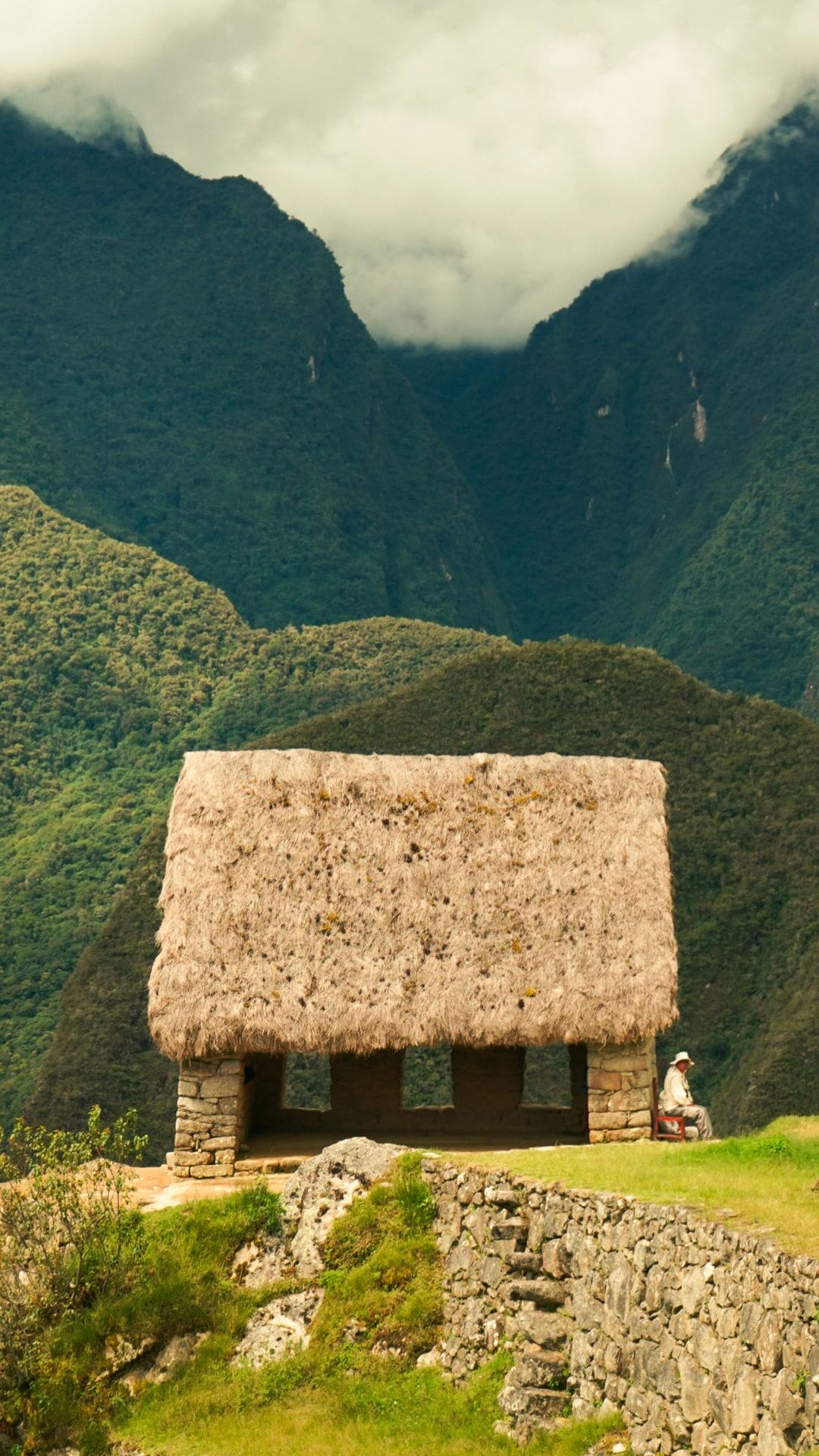 A security guard sits next to a restored hut at Machu Picchu in Aguascalientes, Peru, on March 4, 2026. (Photo by Will King)