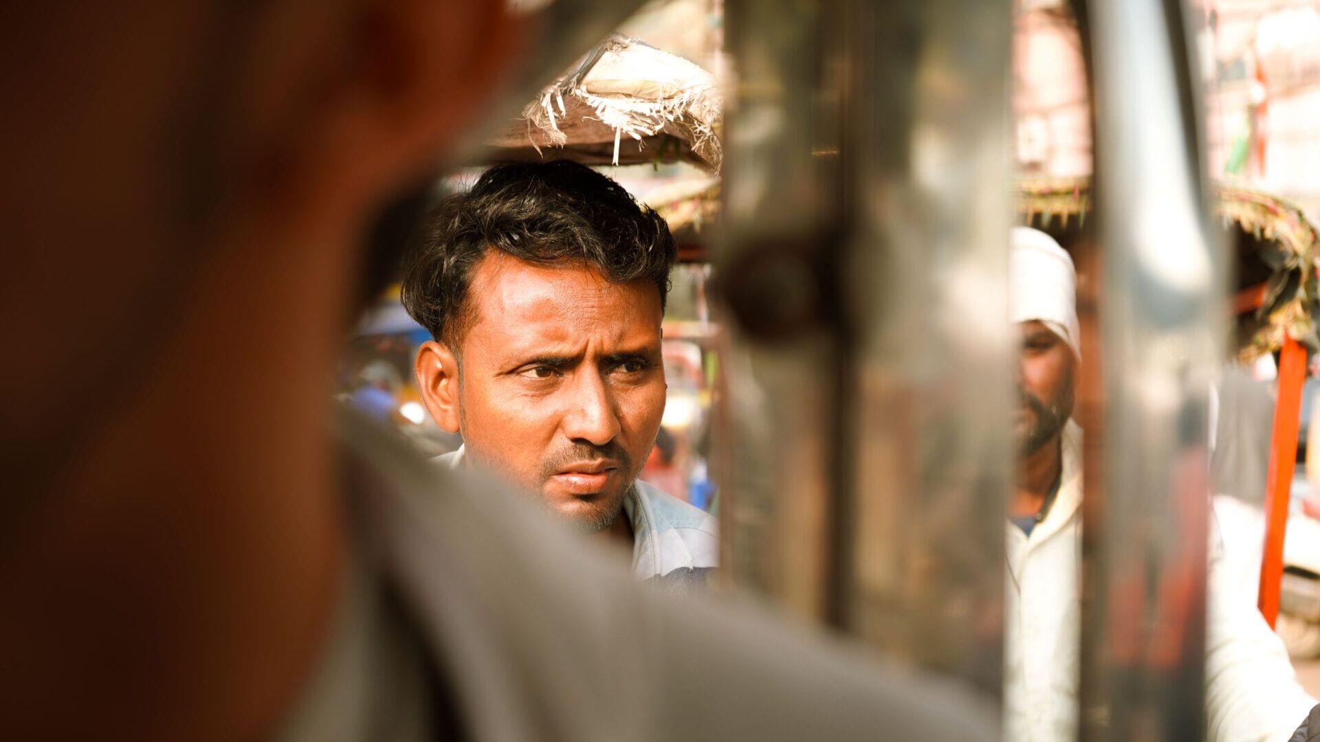 A tuk-tuk driver watches patiently for a red light in a swarm of other drivers in Delhi, India, on Nov. 22, 2025. (Photo by Will King)